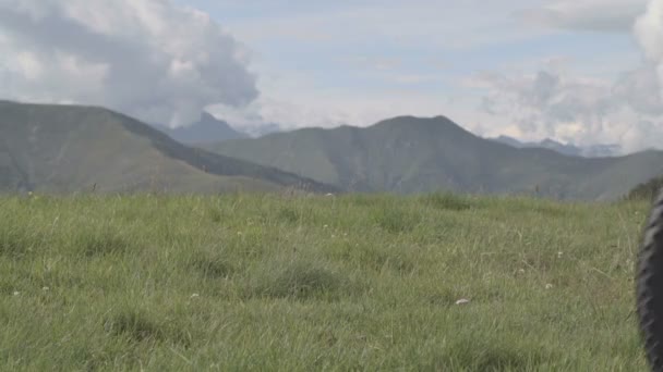 Hombre atlético joven en el día de verano es ciclismo al aire libre en la montaña — Vídeo de stock