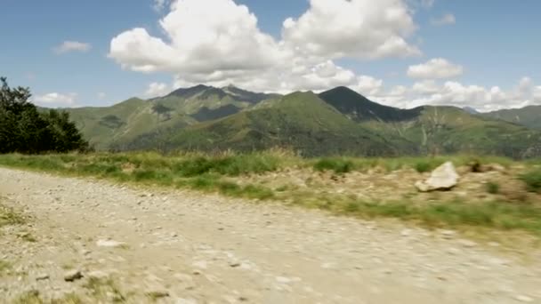 Idąc wzdłuż drogi w górskiej scenerii przyrody odkryty w słoneczny letni dzień — Wideo stockowe