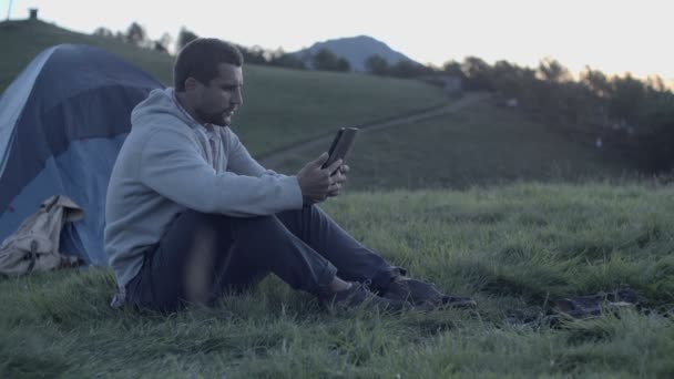 Člověk s použitím tabletu v horské přírodě při západu slunce — Stock video