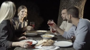 Grup dört mutlu kadın ve erkek arkadaşıyla gülümseme ve içki tost