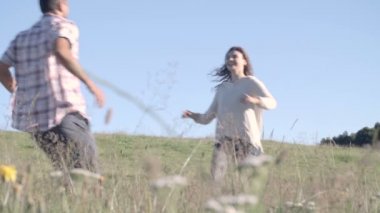 Young man and woman run, hug and walk away hand by hand in outdoor