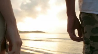 Genç Romantik Çift el gün batımında sahilde tutmak