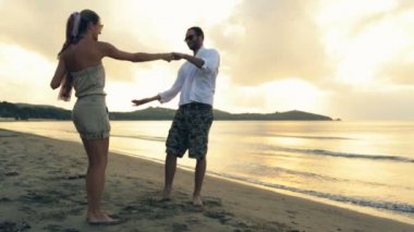 Genç Romantik Çift günbatımında kıyıda yazları açık dans