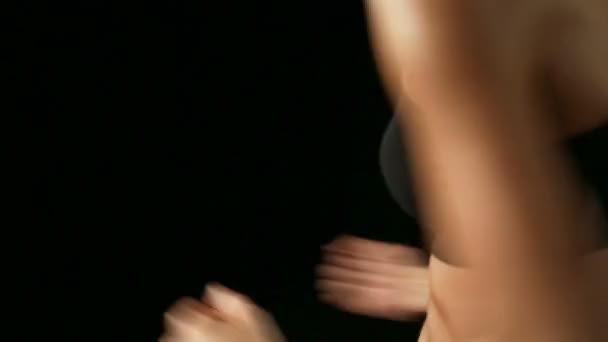 Frau macht Übungen im dunklen Studio — Stockvideo