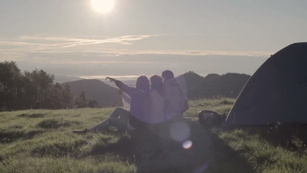 Jóvenes amigos haciendo camping mira el mapa en montaña al aire libre — Vídeo de stock