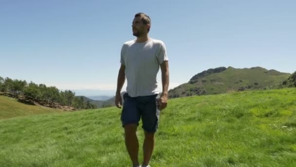 Вид спереди молодого человека, совершающего поход в горы на природе — стоковое видео