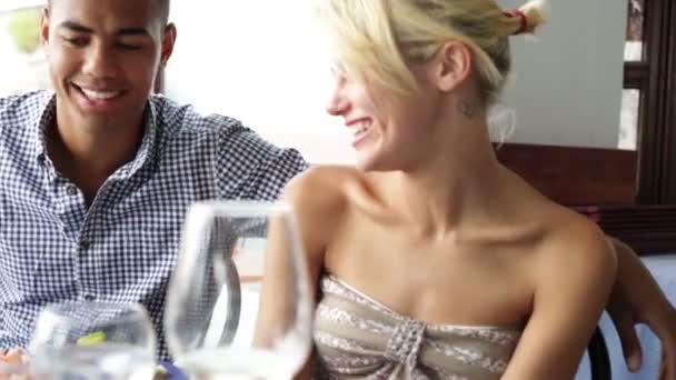 Jong koppel babbelend in restaurant — Stockvideo