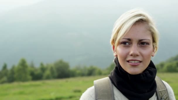 Young beautiful blonde woman is admiring the panorama on mountain — Stock Video