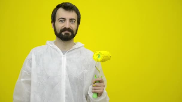 Mann gestikuliert mit gelber Farbrolle — Stockvideo