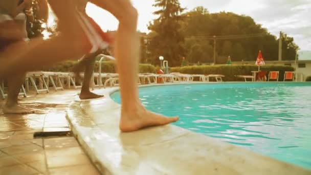 Cuatro jóvenes amigos en el día de verano buceando en la piscina al aire libre — Vídeos de Stock