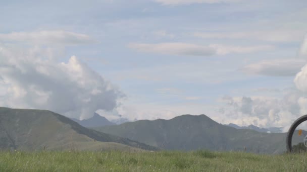 Homem atlético jovem no dia de verão está pedalando ao ar livre na montanha com — Vídeo de Stock