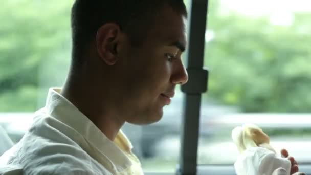 Unga vackra svart man äter en smörgås i ett flyttlass — Stockvideo