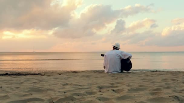 Uomo suona la chitarra al mare sulla spiaggia — Video Stock