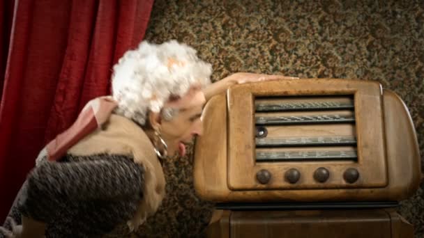 Grappige grootmoeder luistert naar een oude radio — Stockvideo