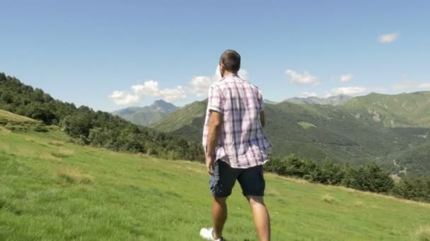 Achterkant en zijaanzicht van de jonge man wandelen in de bergen buiten natuur landschap — Stockvideo