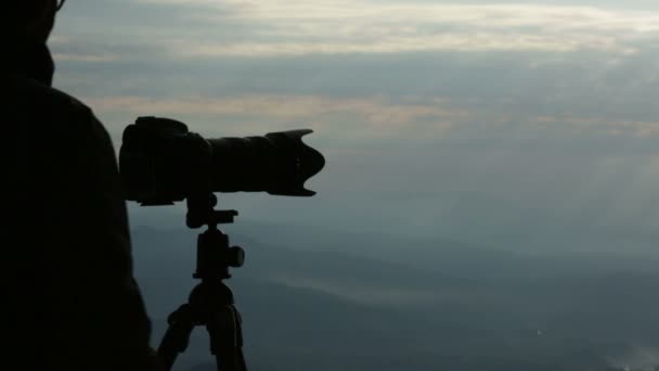 Mladý muž fotograf silueta střílet s digitálním fotoaparátem — Stock video