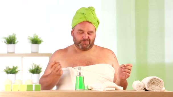 Homme portant des serviettes voler une bougie au spa de santé intérieur — Video