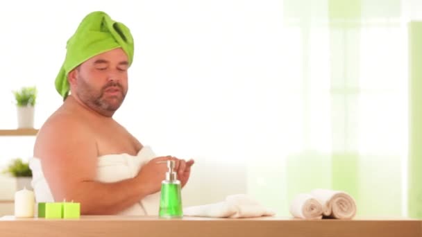 Человек с избыточным весом пьет крем красоты в спа — стоковое видео