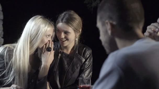 Jovem mulher contar um segredo para seu amigo e sorrir enquanto desfruta aperitivo — Vídeo de Stock