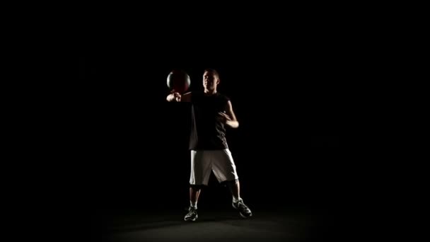 Спортсмен исполняет трюк с баскетболом — стоковое видео