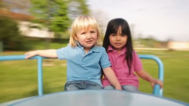 Παιδιά παίζουν στην καλοκαιρινή μέρα στο καρουσέλ — Αρχείο Βίντεο