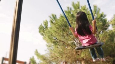 Asyalı çocuk yaz günü salıncak üzerinde oynuyor 