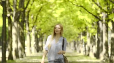 Kentsel şehir Park müzik genç güzel sarışın kız yürüyor