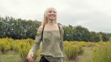 Güzel sarışın genç kızın önden görünüm açık doğa fotoğraf makinesi doğru yürüyor 