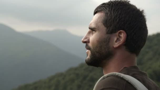 Homem barba bonita jovem na montanha com uma mochila vintage vermelho — Vídeo de Stock