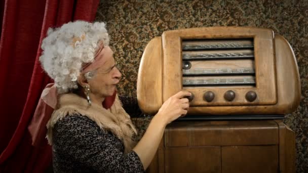 Graciosa abuela está escuchando una vieja radio — Vídeo de stock