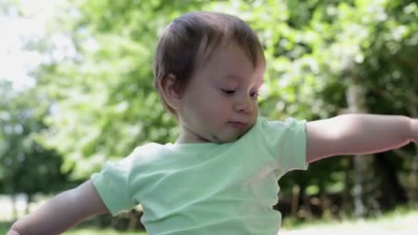 Litet leende blond flicka spela med glasögon i solig sommardag på park — Stockvideo