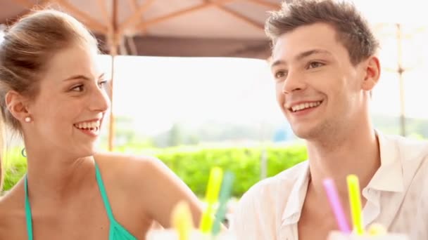 Junges Paar vergnügt sich am Sommertag im Wasserpark und trinkt Cocktails — Stockvideo