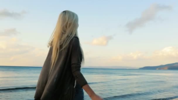 Jovem mulher loira bonita andar na costa ao pôr do sol no verão — Vídeo de Stock