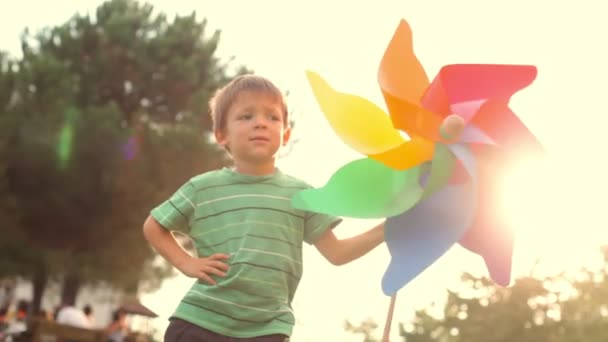 Happy child play with colorful pinwheel — Stock Video