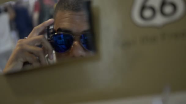 Giovane bellissimo uomo alla stazione di servizio uomo provare su occhiali alla ricerca — Video Stock
