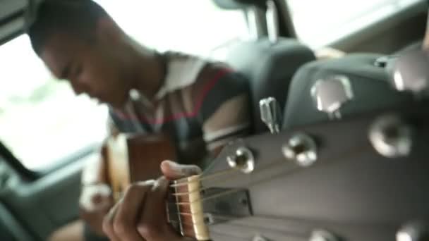 Young man is playing guitar during a travel — Stock Video