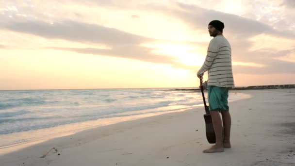 Young beautiful man stands up looking to ocean at beach seaside — Stock Video