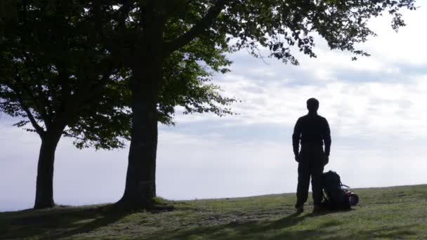 Ung man siluett med ryggsäck star en promenad i naturen — Stockvideo