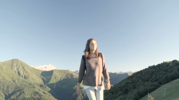山の自然の風景の中でカメラに向かってハイキングする若い女性の正面図 — ストック動画