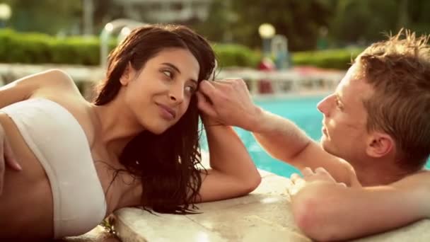 Hermosa pareja romántica joven divertirse en la piscina — Vídeos de Stock