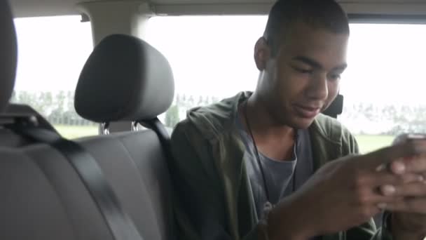 Joven hombre negro hermoso está enviando mensajes con su teléfono inteligente — Vídeos de Stock