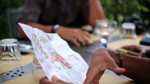 Τέσσερις φίλοι σε ιταλικό εστιατόριο κοιτάζουν έξω σχεδιασμό χάρτη σύντομο ταξίδι — Αρχείο Βίντεο