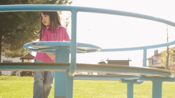 Asiatisches Kind spielt im Sommertag auf Karussell — Stockvideo