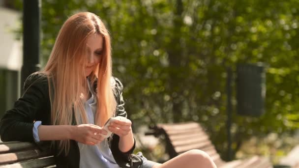 Молода красива блондинка відправляє повідомлення зі смартфоном — стокове відео