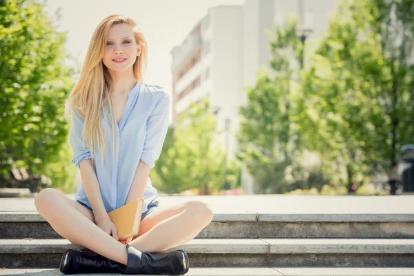 Blonde jonge vrouw lachend ontspannen in een tuin — Stockfoto