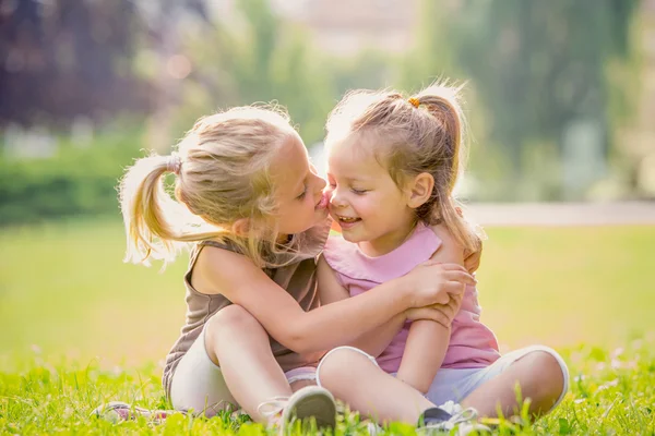 Blonde lächelnde Schwester spielt im Garten — Stockfoto