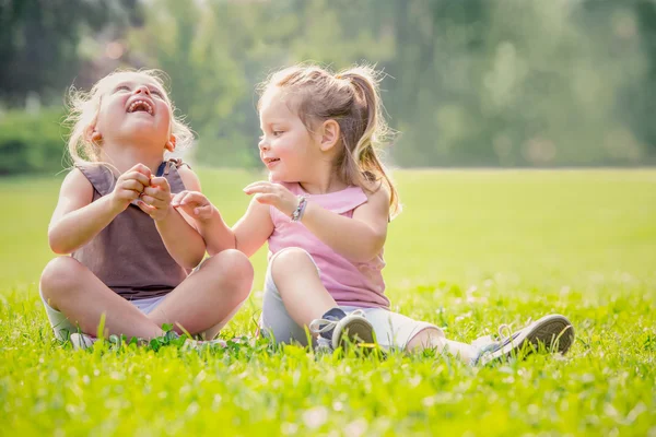Sarışın gülümseyen kız kardeşi bir bahçede oyun — Stok fotoğraf