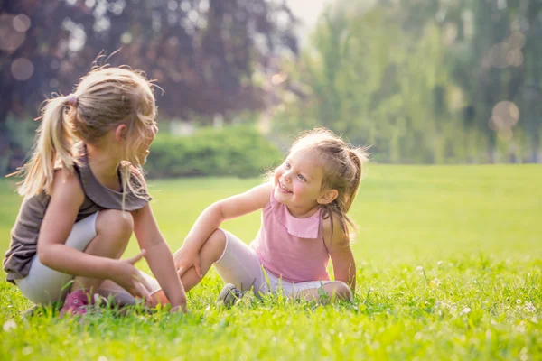 Blonde lächelnde Schwester spielt im Garten — Stockfoto