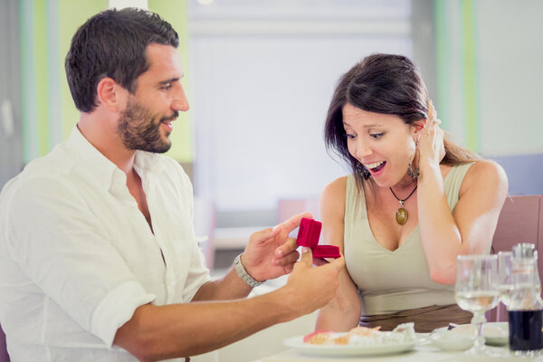 young romantic man proposal to girlfriend at restaurant