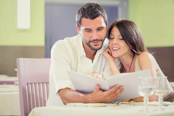 Junges romantisches brünettes Paar liest Menü im Restaurant — Stockfoto